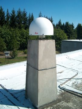 LEICA LEIAT504GG (choke ring + LEIS dome) GNSS antenna and the concrete pillar on the roof of the building (receiver: LEICA GRX1200GGPRO).
