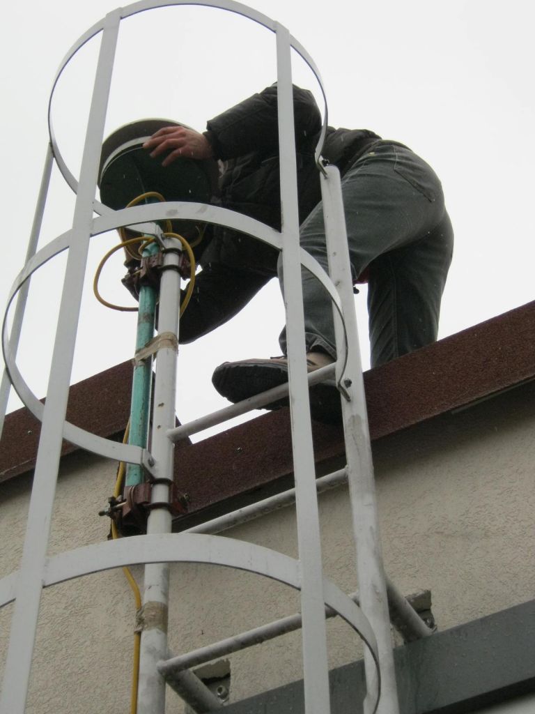 Working on installation of the GNSS antenna on the roof of the local cadastre office.