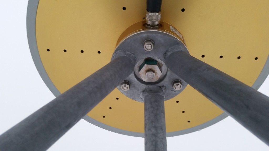 The attachment of the antenna to the top of the steel grid mast.