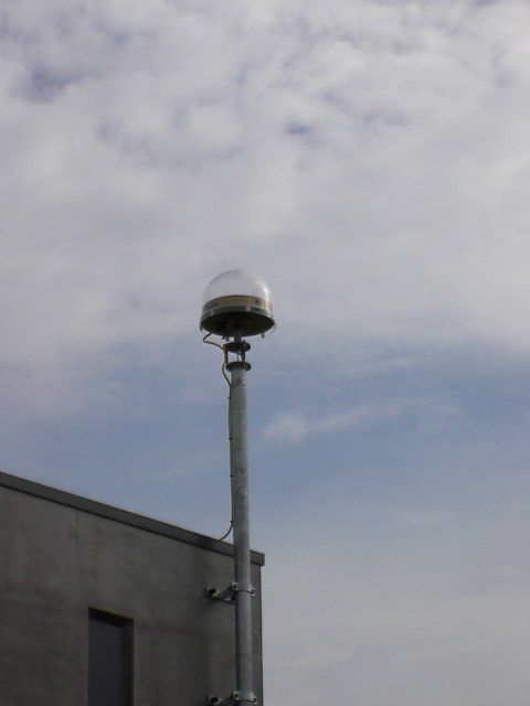 Trimble chokering antenna with UNAV radome, on short mast, at the Vlissingen tide-gauge station