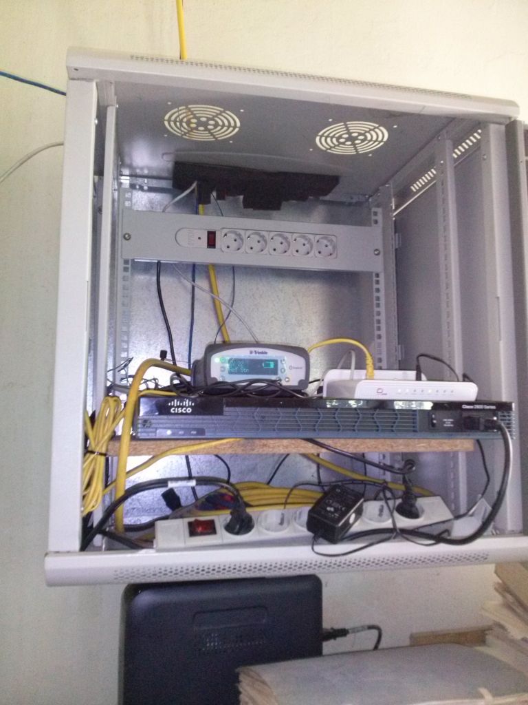 The rack cabinet with Trimble Ethernet NETR9 CORS receiver with belonging power supply, the emergency power system, antenna cable, IT equipment. Receiver display showing the larger number of tracked satellites