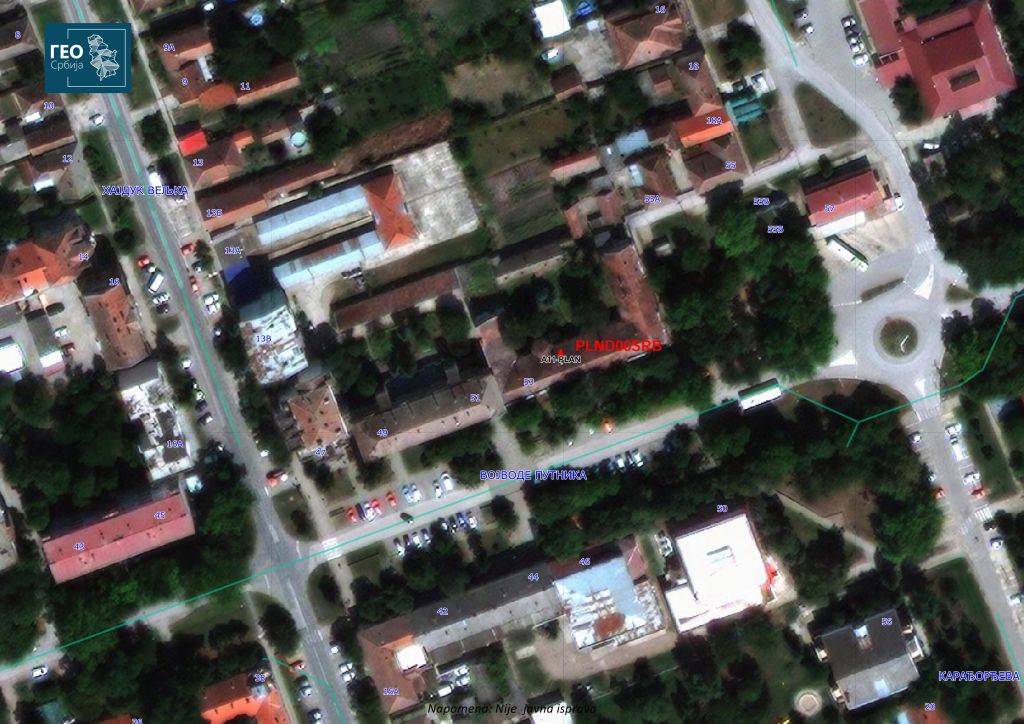 The RGA reference CORS point PLND00SRB location overlayed on the satellite image map of Plandiste municipality together with neighboring street names of Serbian NSDI address register. The red triangle represents the GNSS antenna position on the roof of local cadaster building. 