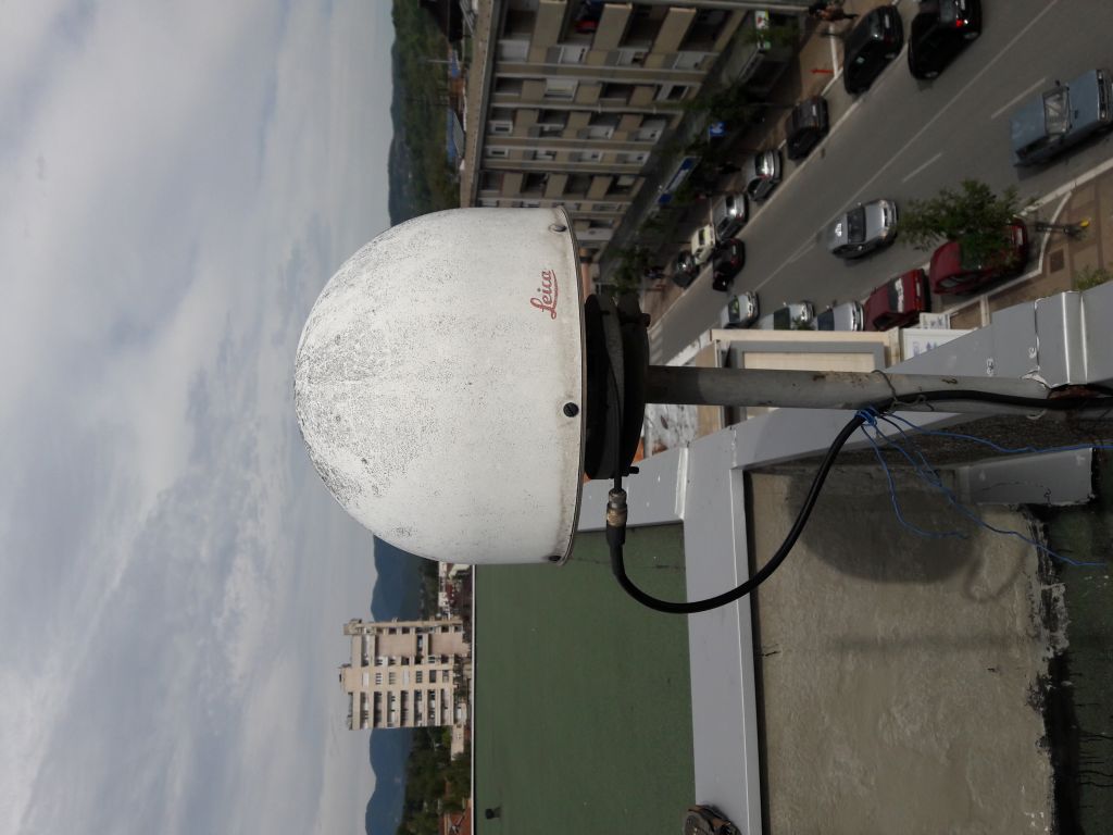 Old GNSS antenna LEIAT504 with LEIS dome installed on iron pillar on building roof