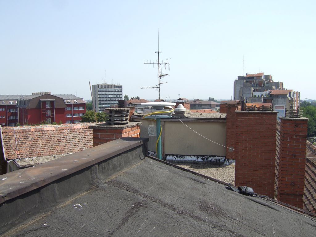 The installation of the iron pillar with a mounting plate  on the roof of local cadaster building. The preview of local surroundings of Trimble Zephyr Geodetic antenna. The pillar is attached on the concrete wall.