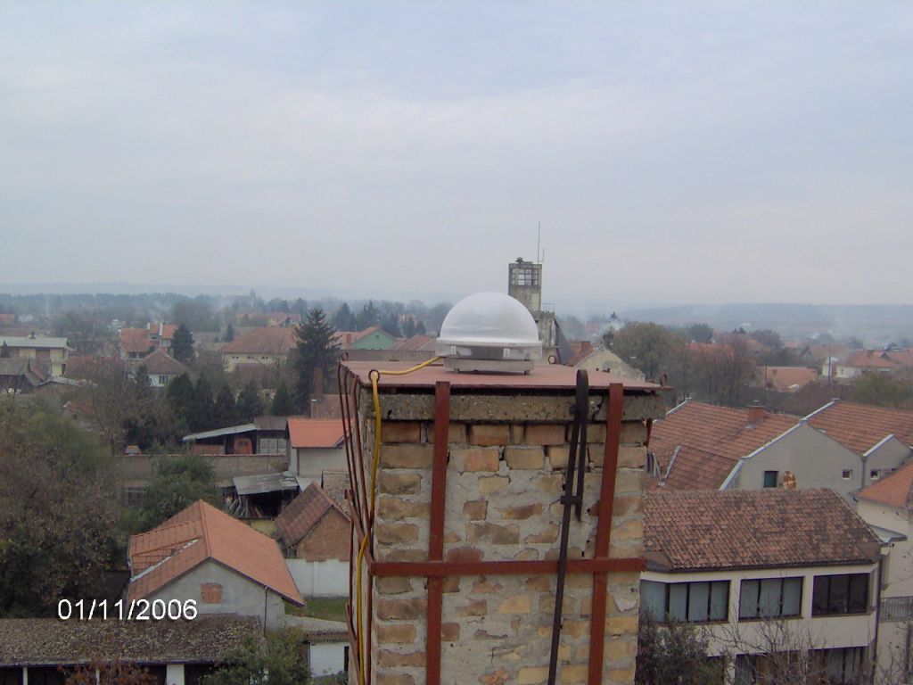 Trimble antenna TRM41249.00 with TZGD protective radome installed on a flat iron console attached for the brick chimney on the local cadaster building roof.