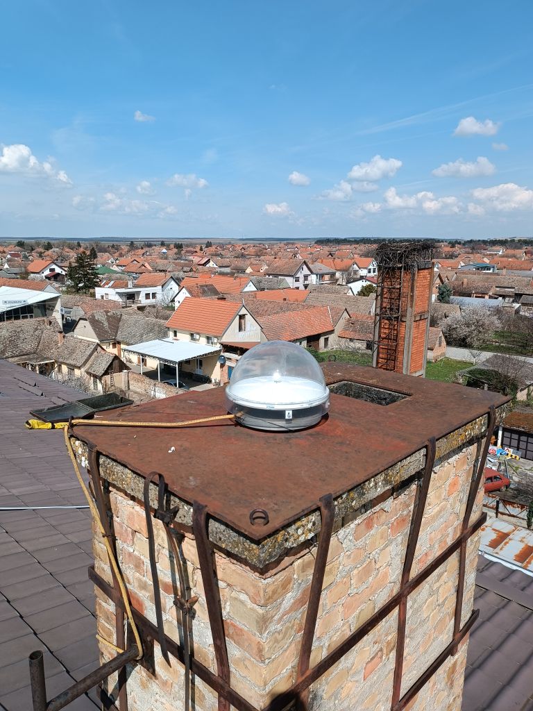 The close view of Trimble Zephyr 3 Geodetic antenna installed on the metal console attached to the brick chimney on the cadaster building roof in Sid municipality