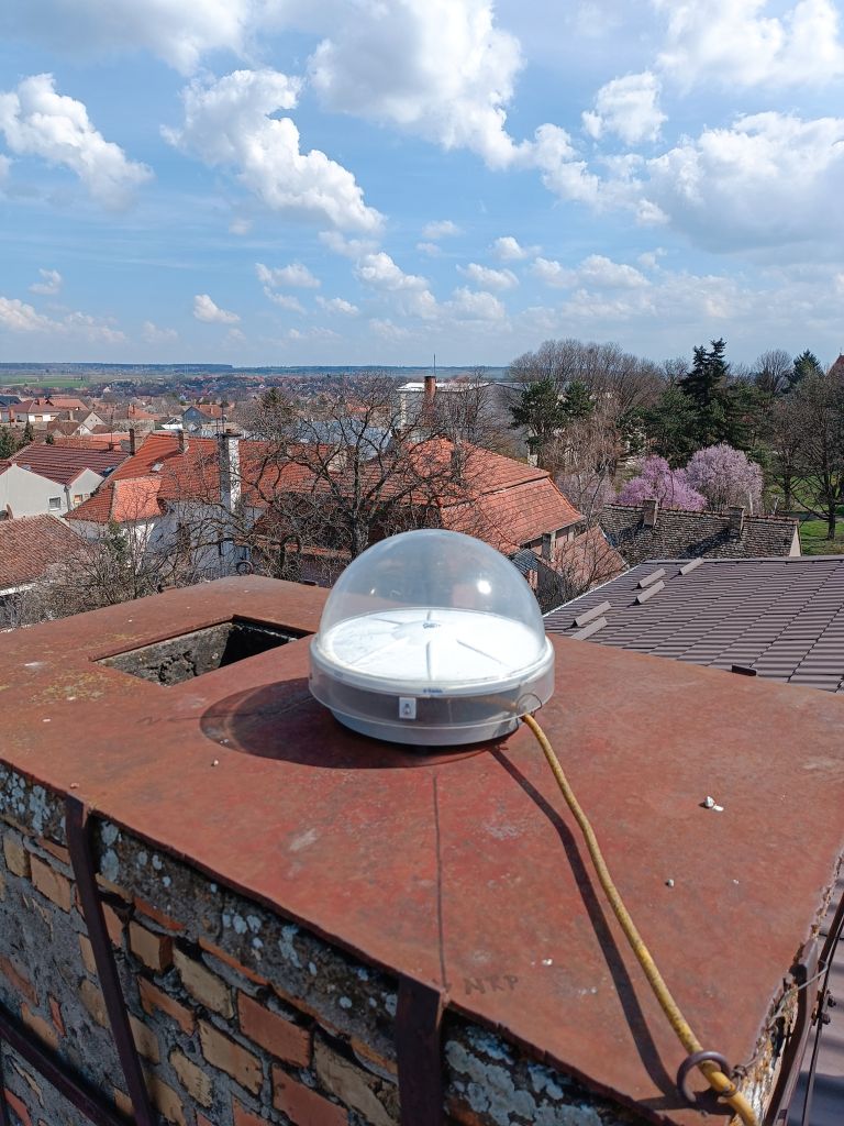 Trimble CORS antenna TRM115000.00 with TZGD radome installed on the brick chimney on the roof of the local cadaster building in Sid municipality.