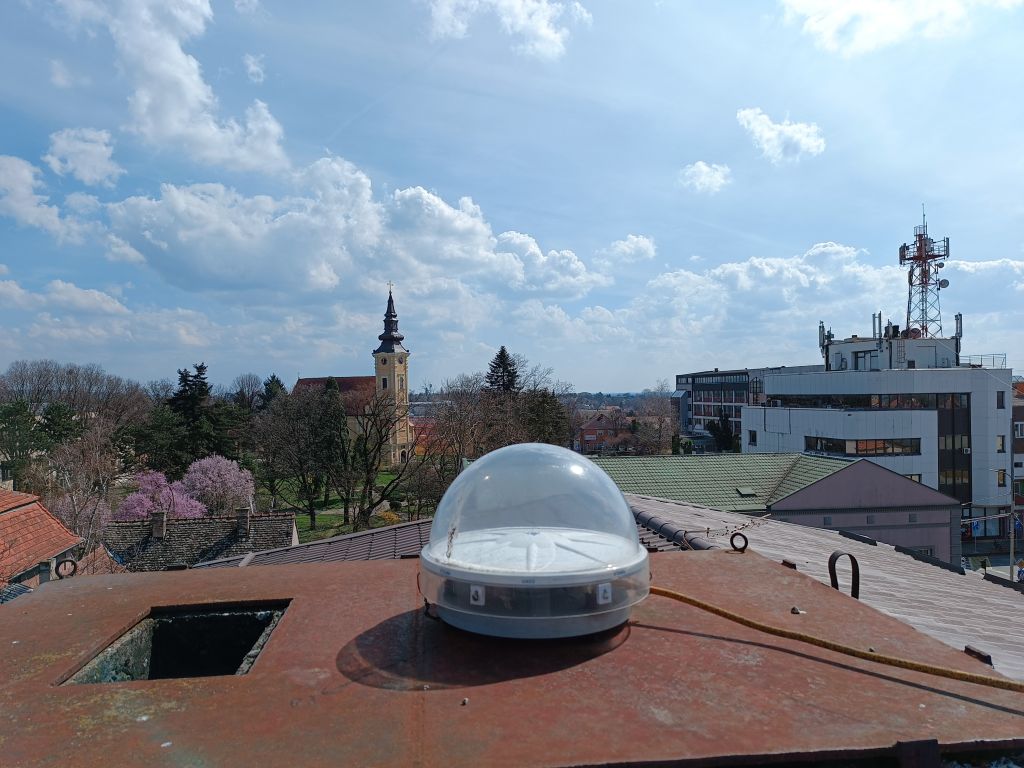 Trimble CORS antenna TRM115000.00 with TZGD radome installed on the brick chimney on the roof of the local cadaster building in Sid municipality.