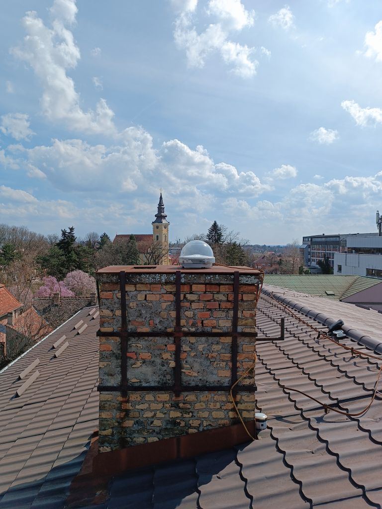 Trimble CORS antenna TRM115000.00 with TZGD radome installed on the brick chimney on the roof of local cadaster building in Sid municipality.