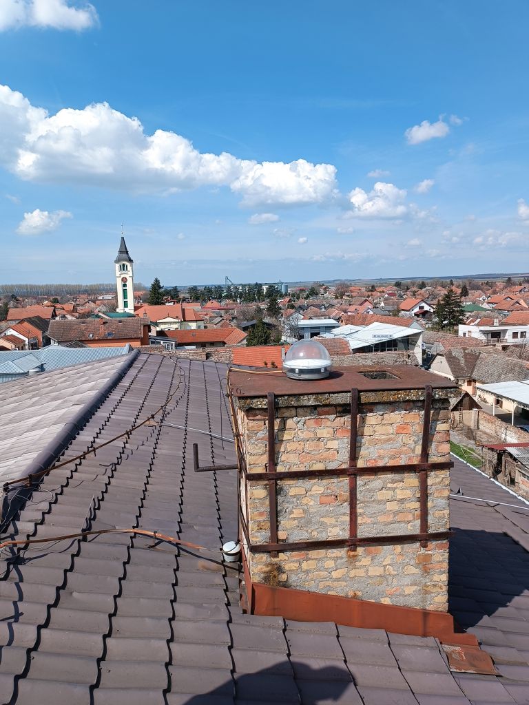 Trimble CORS antenna TRM115000.00 with TZGD radome installed on the brick chimney on the roof of local cadaster building in Sid municipality.